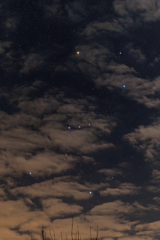 Созвездие Ориона видно через облака на фотографии астрофотографа Panagiotis X | Про космос